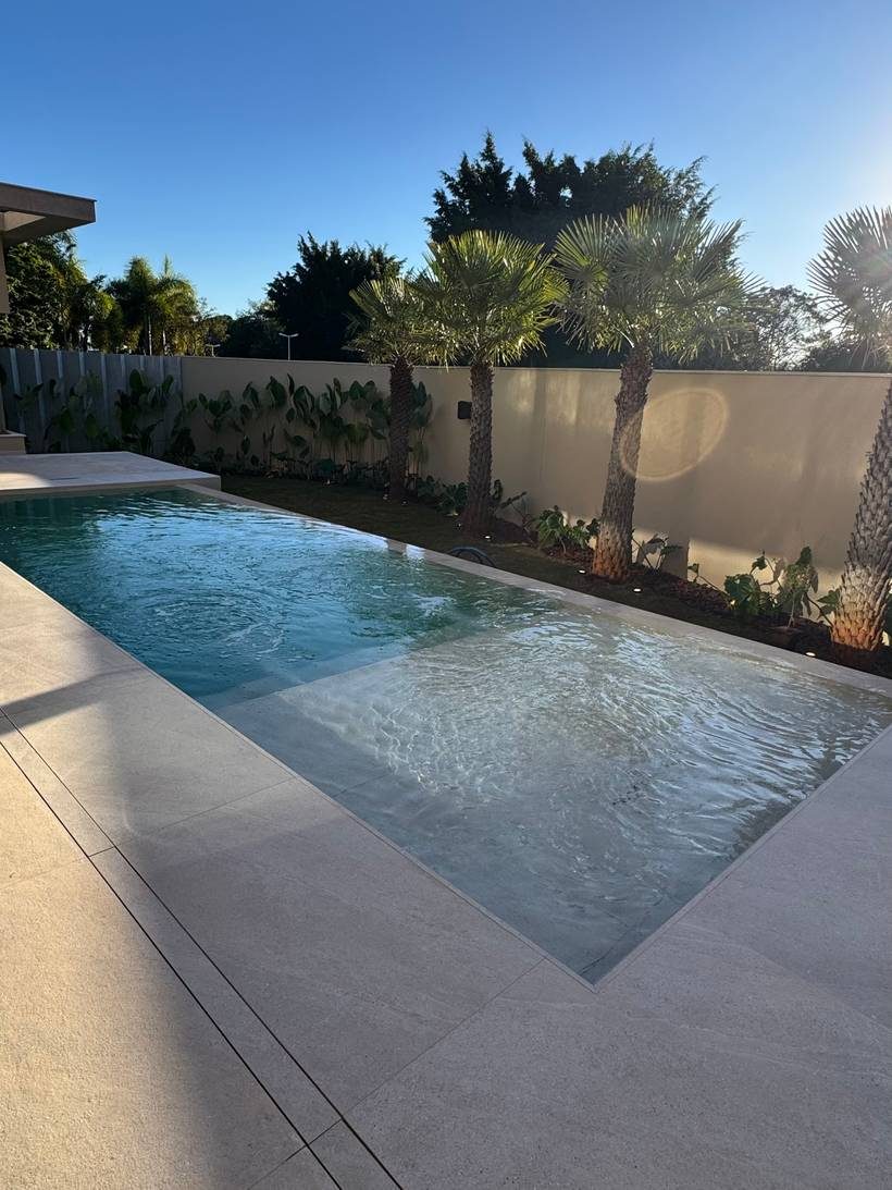 Piscina com prainha e deck claro